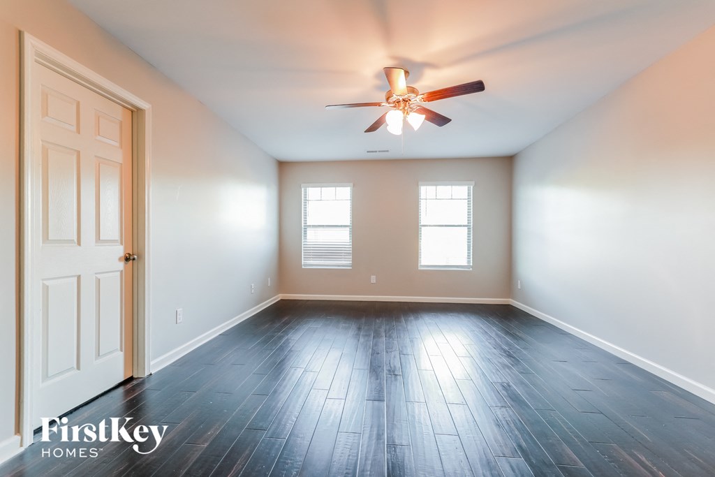 an empty room with a ceiling fan and wood floors