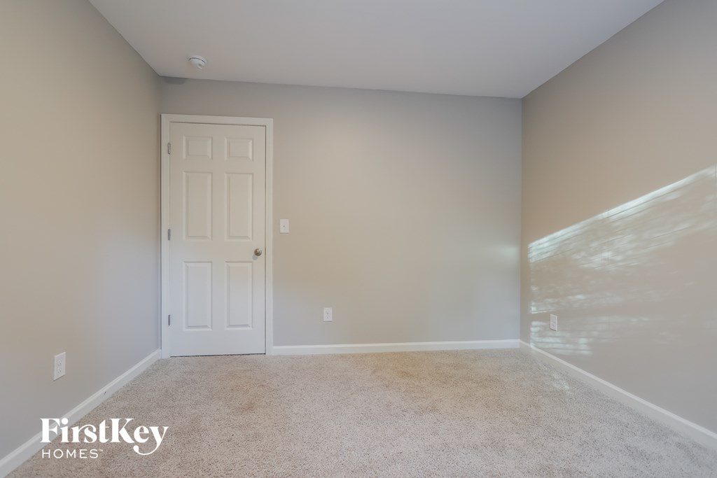 a empty room with a white door and carpet