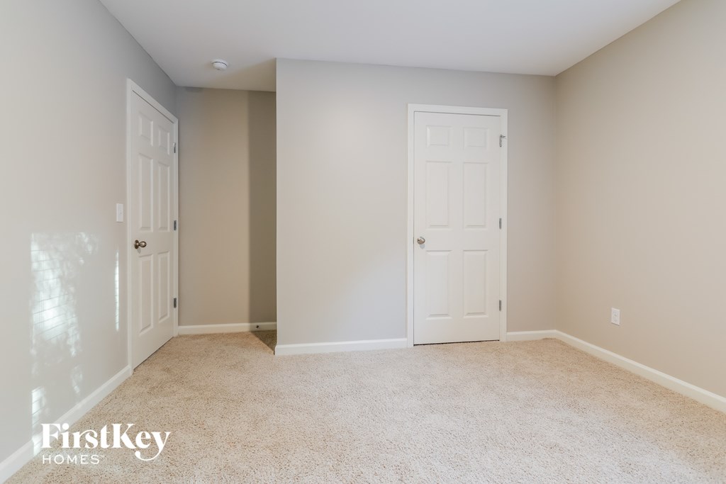 a bedroom with two doors and a carpeted floor