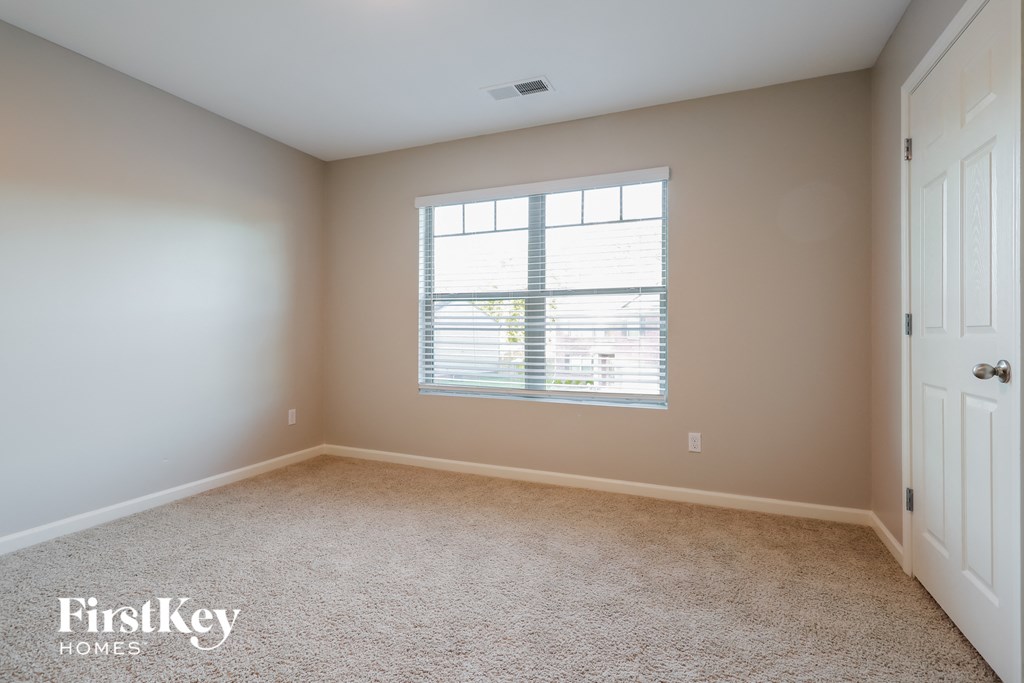 a bedroom with a window and a white door