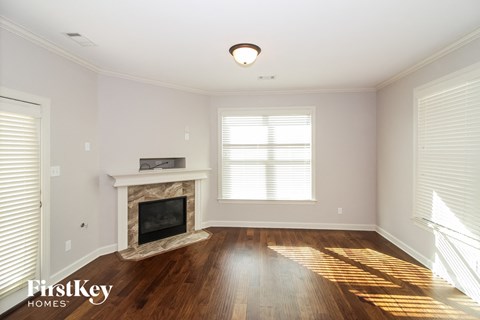 a living room with a fireplace and wooden floors