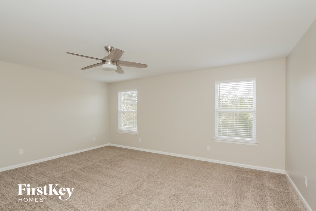 a bedroom with a ceiling fan and a carpeted floor