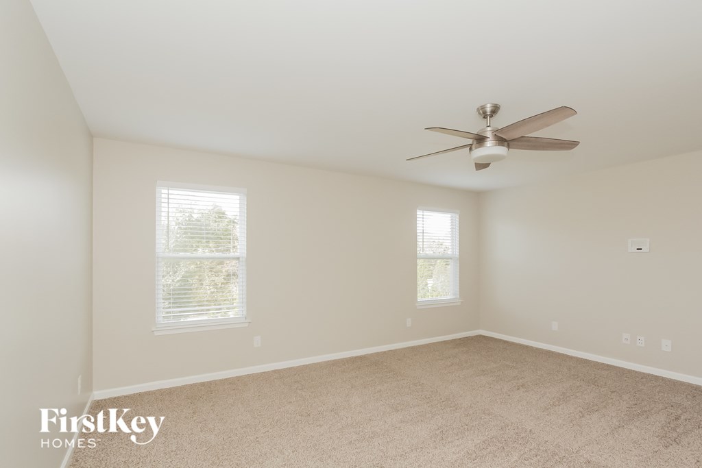 a room with carpet and a ceiling fan