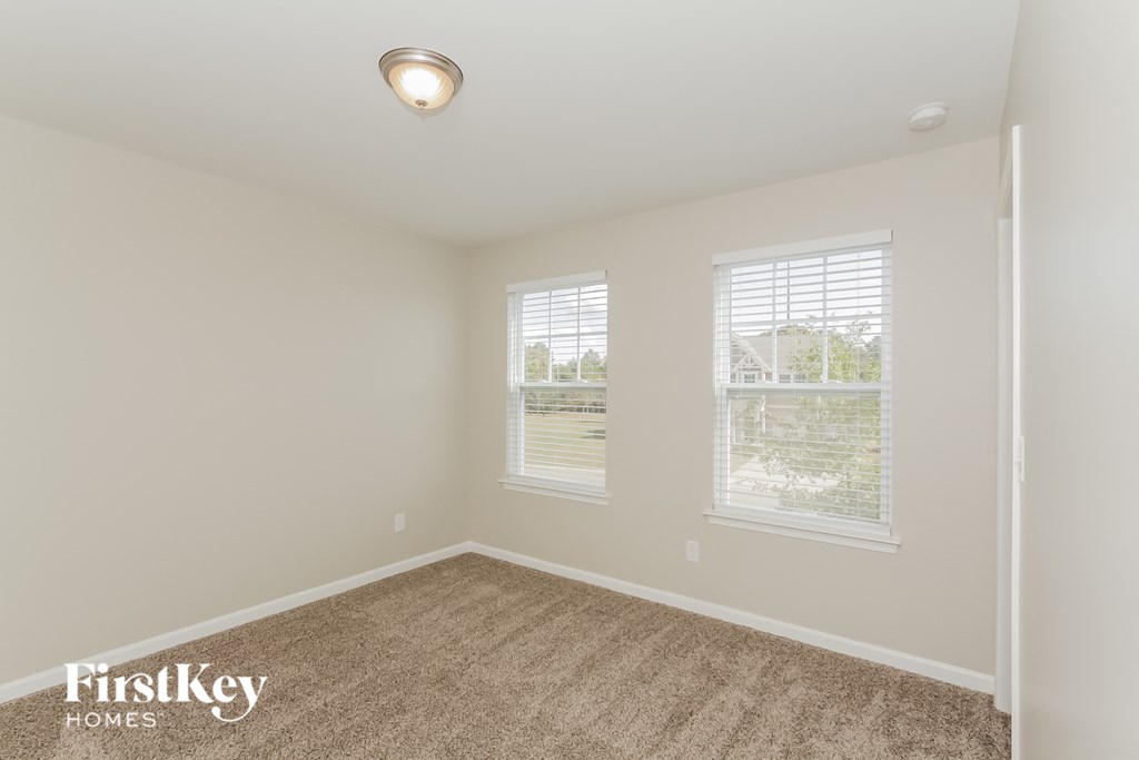 a bedroom with a carpeted floor and two windows