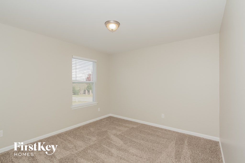 a bedroom with a carpeted floor and a window