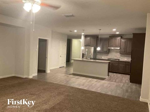 A spacious kitchen with a dining area and a living room.