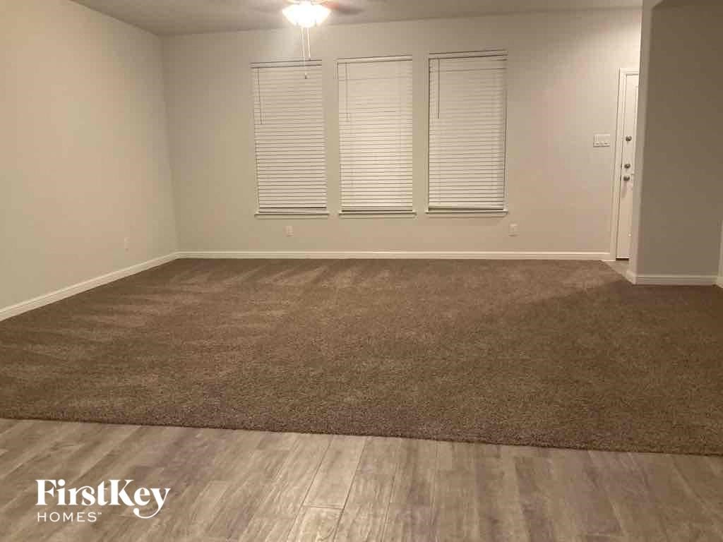 A room with a carpeted floor and a door on the right side.