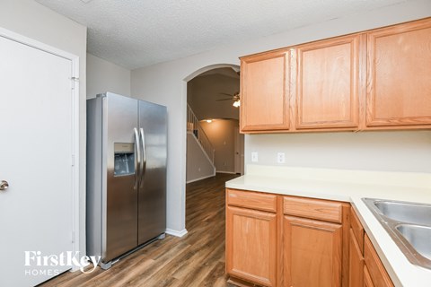 A kitchen with wooden cabinets and a stainless steel refrigerator.