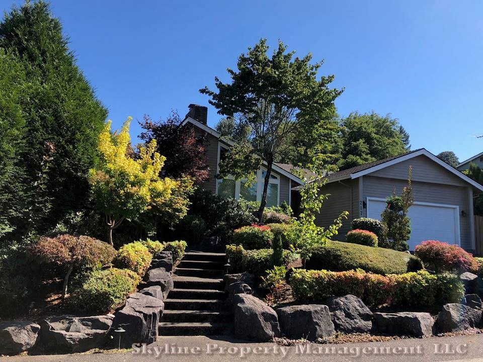 a house with stairs and landscaping in front of it