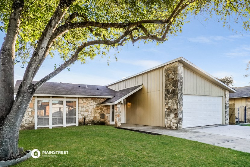 a white and tan house with a tree in the yard