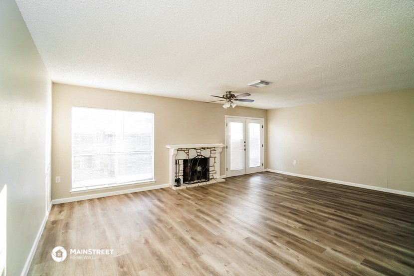 an empty living room with wood floors and a fireplace
