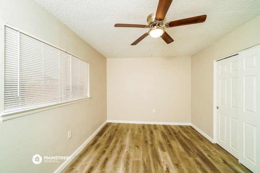 a bedroom with a ceiling fan and a window