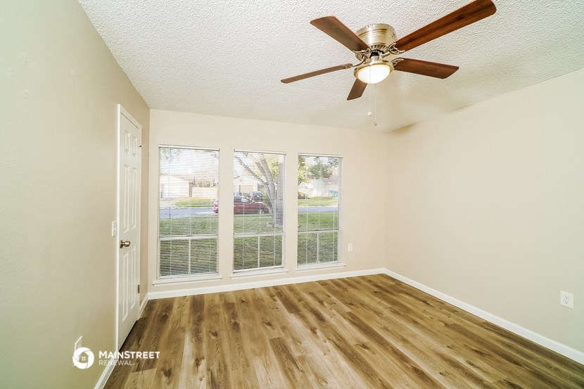 a living room with a ceiling fan and a window