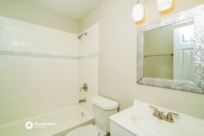 a bathroom with a sink toilet and tub and a mirror
