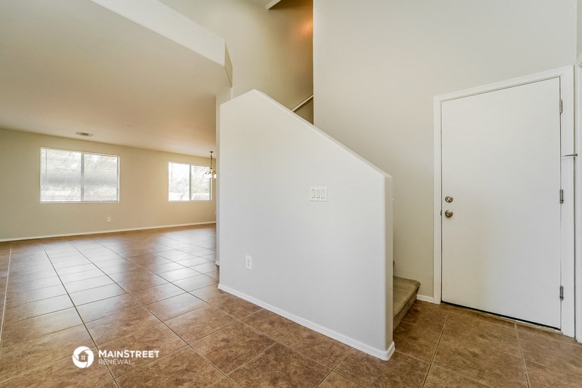 an empty living room with a white wall and a door