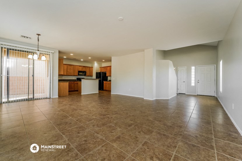 the spacious living room with the kitchen in the background