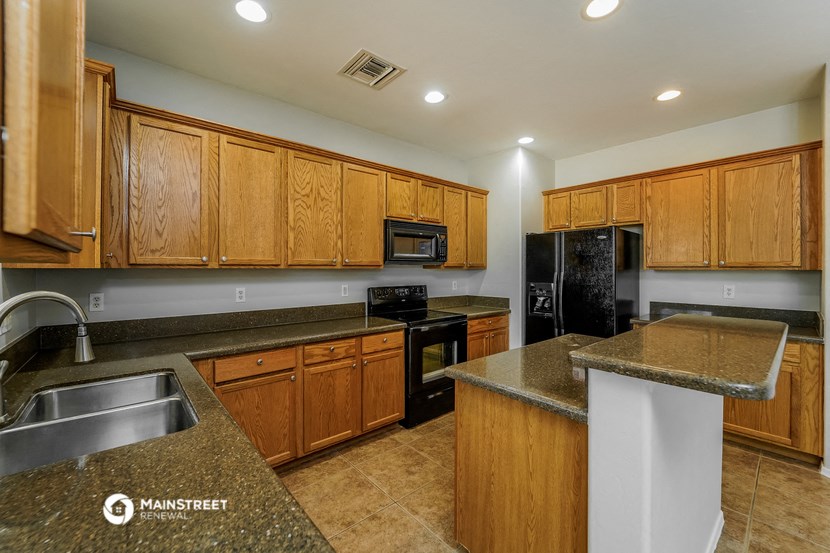 a kitchen with wood cabinets and granite counter tops and black appliances