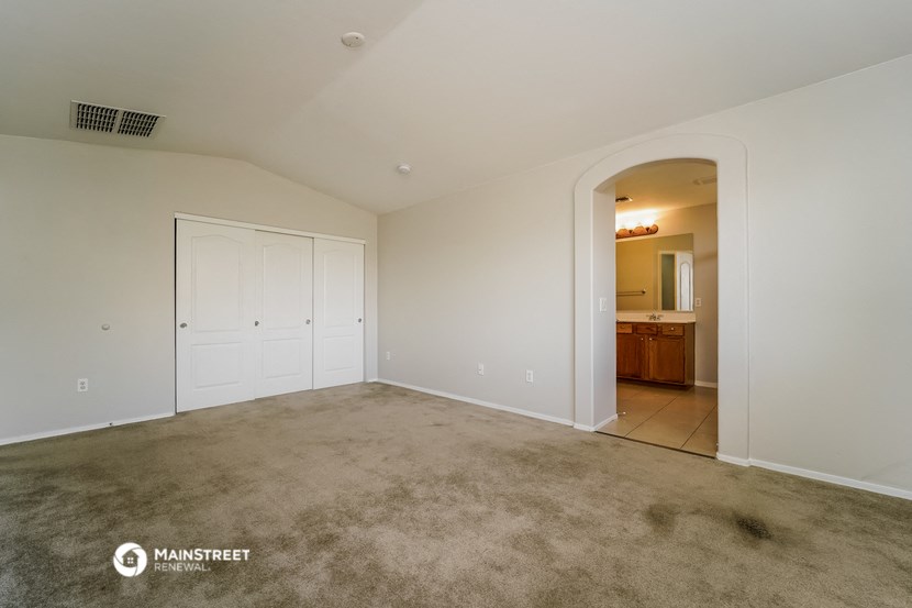 an empty living room with white walls and a door to a bathroom