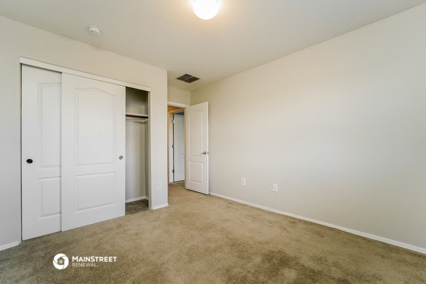 a bedroom with two closets and a carpeted floor