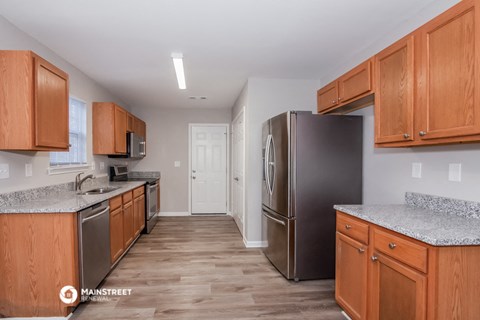 a kitchen with wooden cabinets and stainless steel appliances and granite counter tops