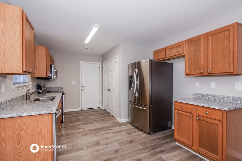 a kitchen with wooden cabinets and a stainless steel refrigerator