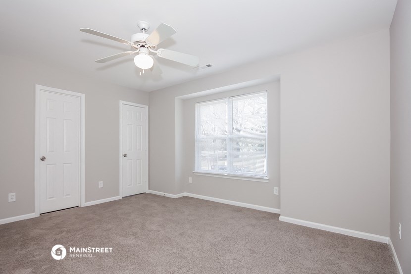 a bedroom with a ceiling fan and a window