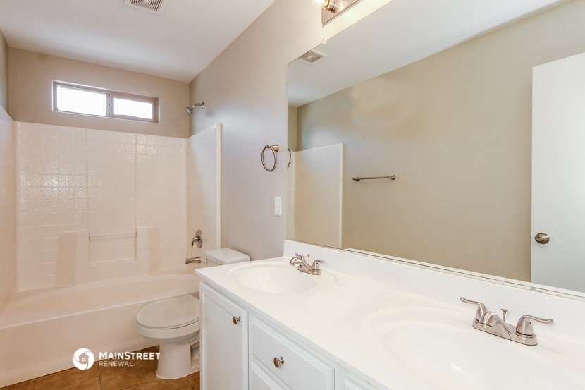 a bathroom with two sinks and a shower and a toilet