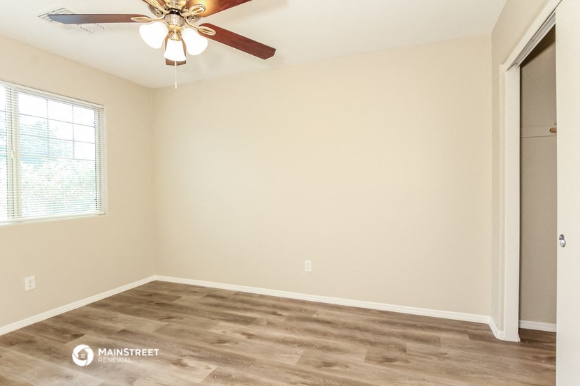 a bedroom with a ceiling fan and a window