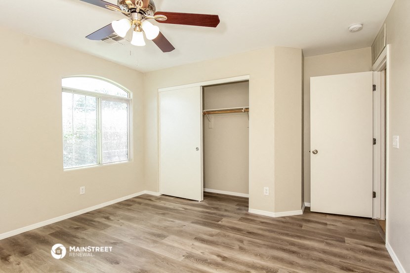 an empty room with a ceiling fan and a closet