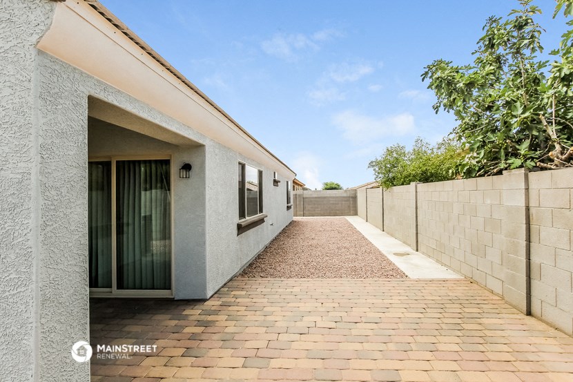 the entrance to a house with a brick walkway and a fence