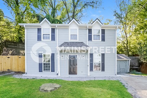 a white house with blue shutters and a lawn