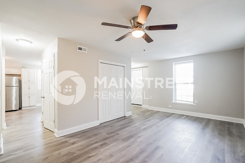 a renovated living room with a ceiling fan and hardwood floors