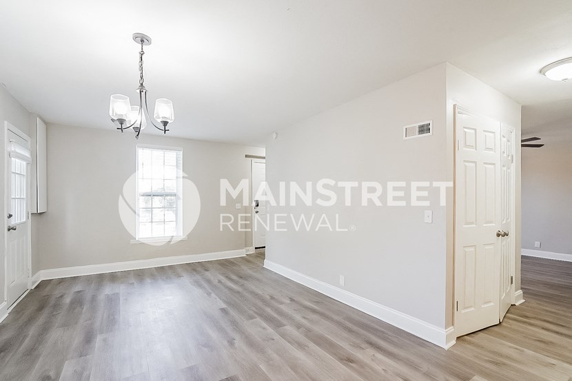 a living room with white walls and a white door    and a door