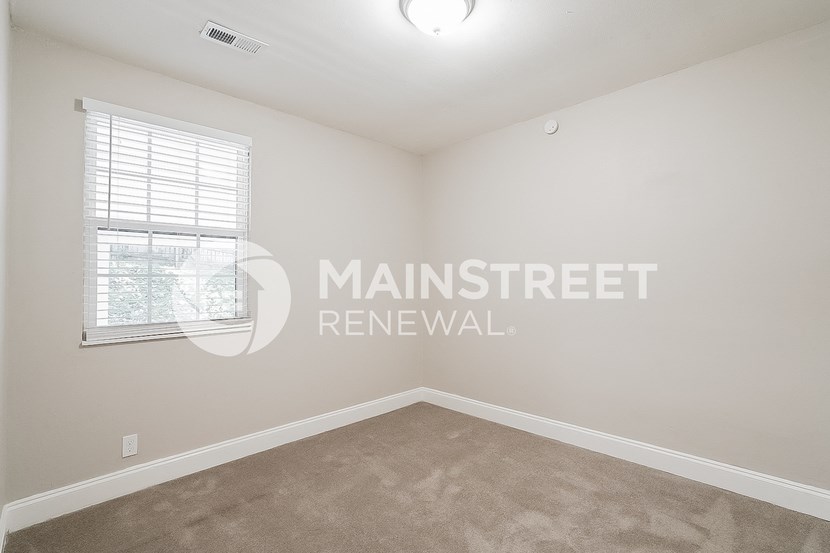 a bedroom with carpet and a window