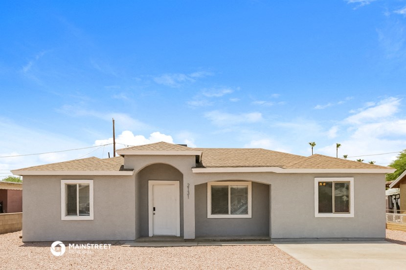 a small beige house with a door and a blue sky