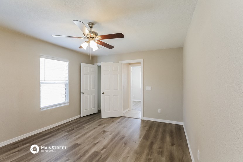 the spacious living room with ceiling fan and door to the closet