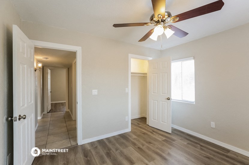 the living room and hallway of a renovated house with a ceiling fan