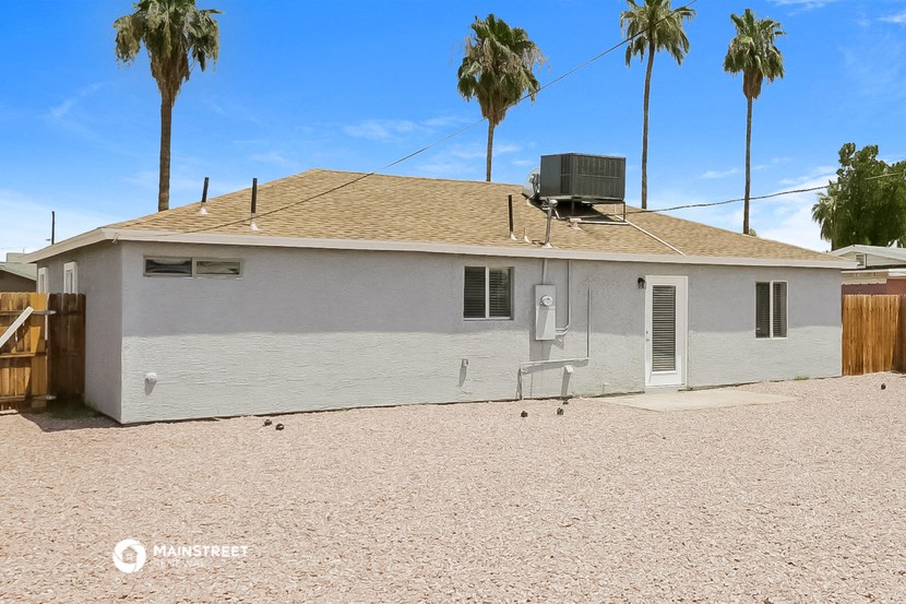 a small white house with palm trees in the background