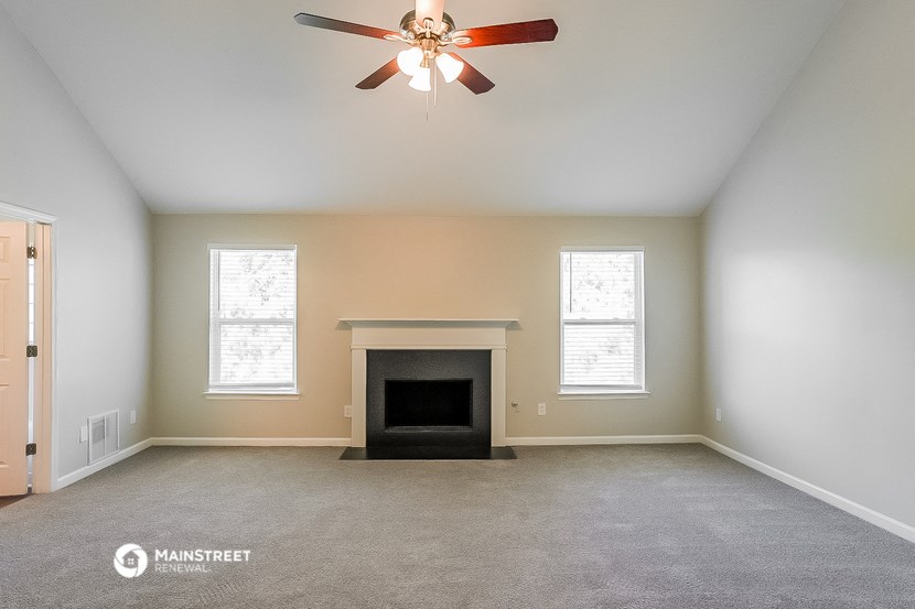 the living room with fireplace and ceiling fan