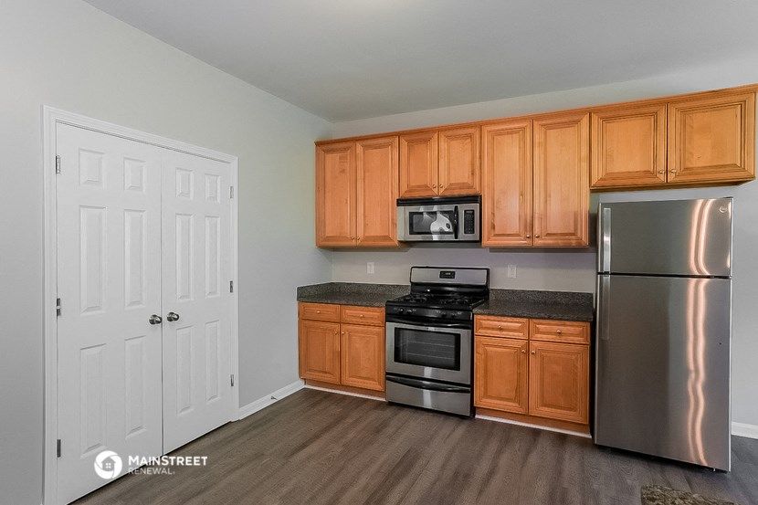 a kitchen with wooden cabinets and stainless steel appliances