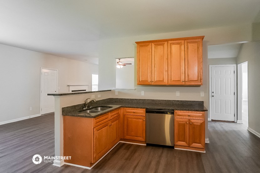 a kitchen with wooden cabinets and a counter top and a sink