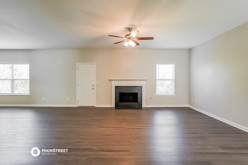 the living room with fireplace and ceiling fan