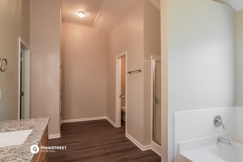 a bathroom with a tub and a shower and a sink