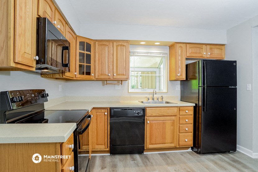 a kitchen with wooden cabinets and black appliances