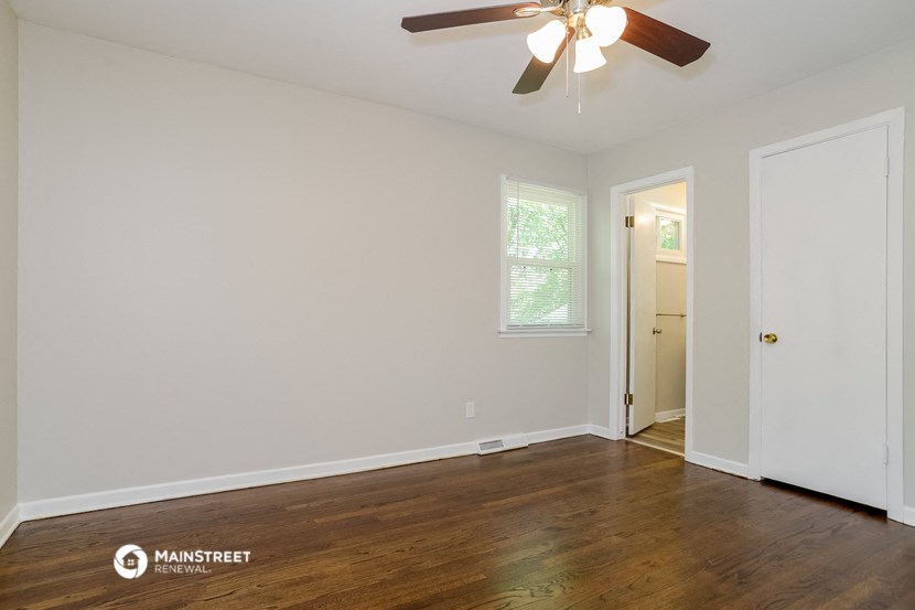the living room of an empty house with wood floors and a ceiling fan