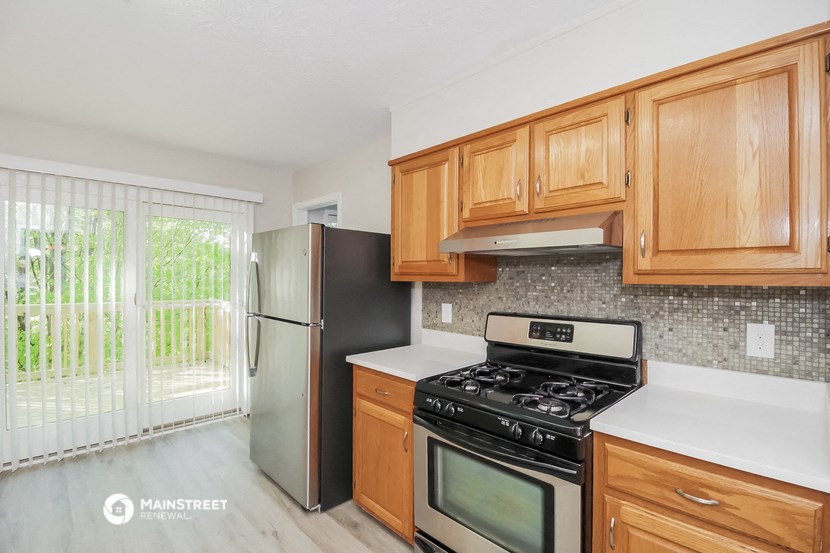 a kitchen with wood cabinets and stainless steel appliances and a sliding glass door