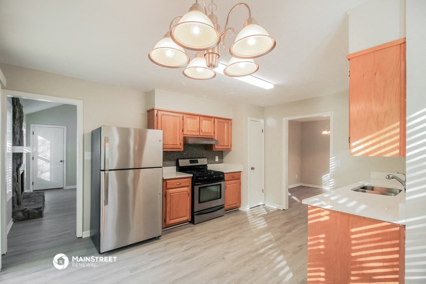 a kitchen with wooden cabinets and a stainless steel refrigerator
