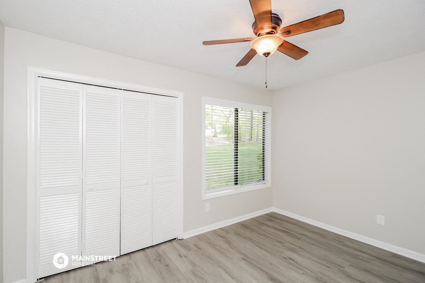 a living room with a ceiling fan and a large window