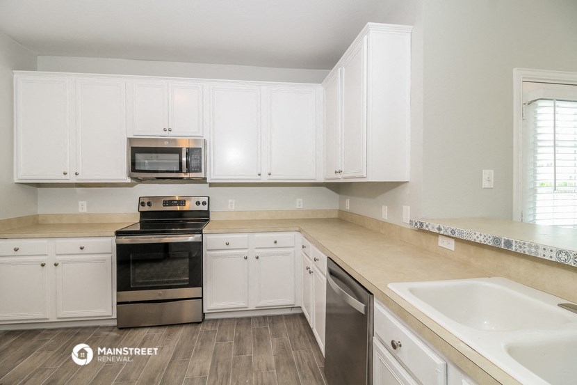 a kitchen with white cabinets and stainless steel appliances