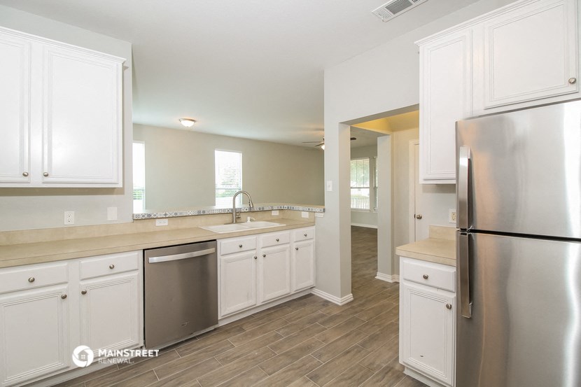 a kitchen with white cabinets and stainless steel appliances